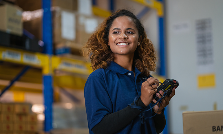 Woman smiling while working in a warehouse.