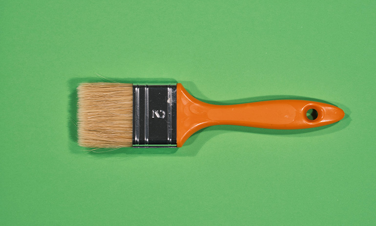 A green background with a brown paintbrush resting on top.