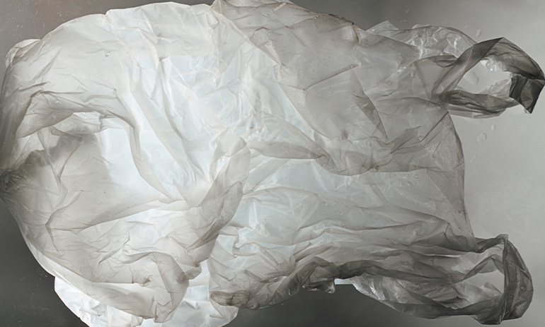 A grey plastic bag glowing from behind with light.