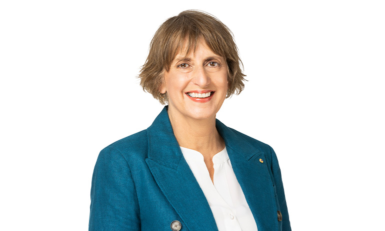 Sue Woodward, the ACNC commissioner, smiles in a profile picture. She is wearing a blue blazer and white shirt, and has cropped dark blonde hair.