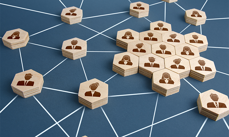 Workers on wooden blocks connected together to symbolise a large organisation.