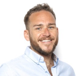 Headshot of Ben smiling in a light blue shirt.